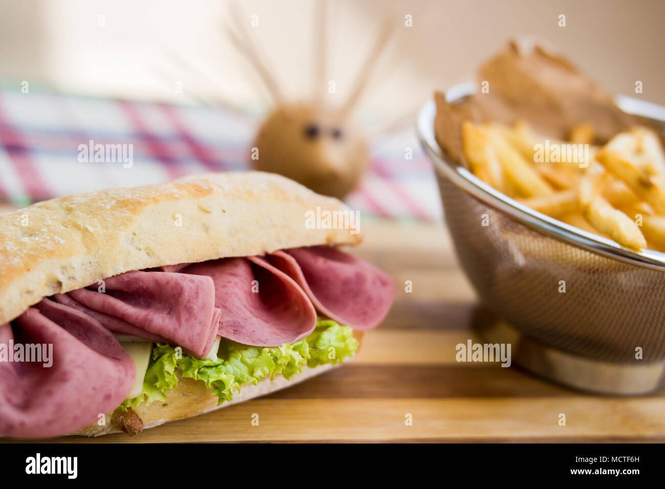 In casa panino di prosciutto con patate fritte (patatine fritte), ketchup e maionese Foto Stock