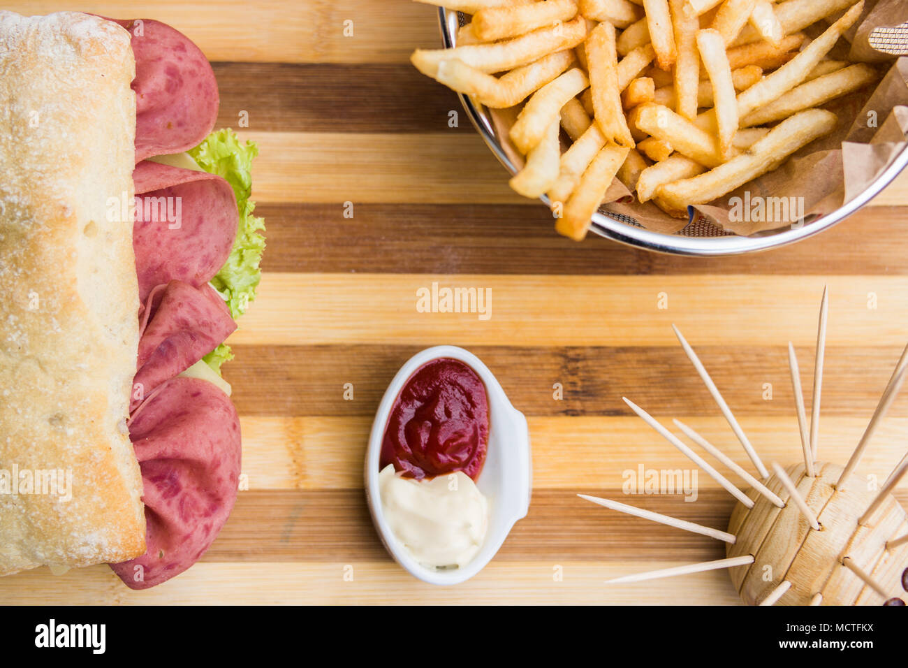In casa panino di prosciutto con patate fritte (patatine fritte), ketchup e maionese Foto Stock