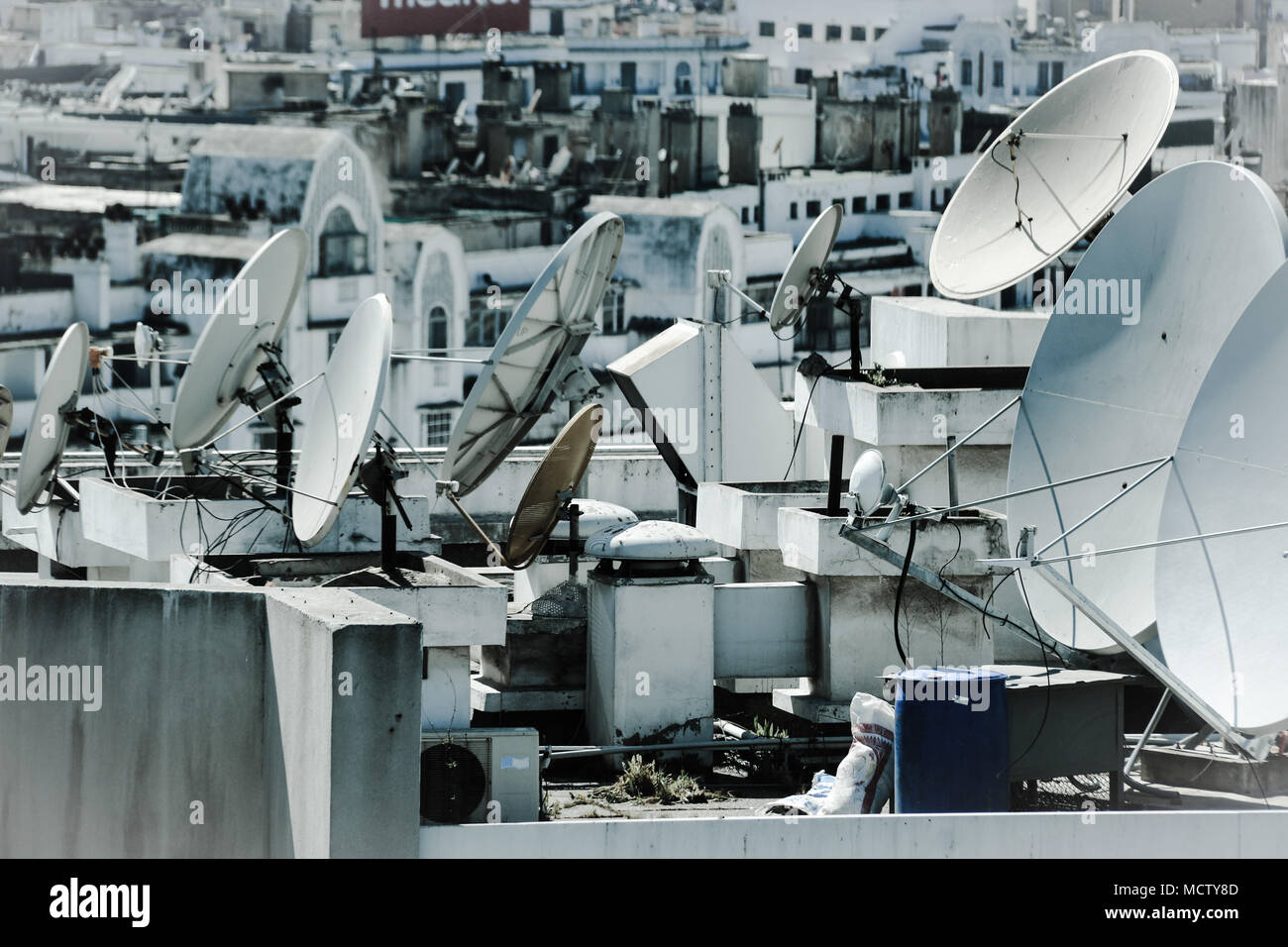 In vecchio stile immagine utilizzando un filtro di antenne paraboliche per la ricezione satellitare su un tetto di un edificio alto in Casablanca, Marocco Foto Stock