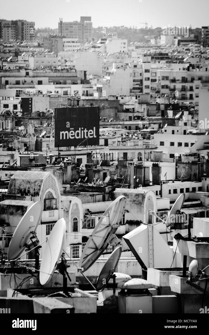 Vecchia immagine in bianco e nero di antenne paraboliche per la ricezione satellitare su un tetto di un edificio alto in Casablanca, Marocco Foto Stock