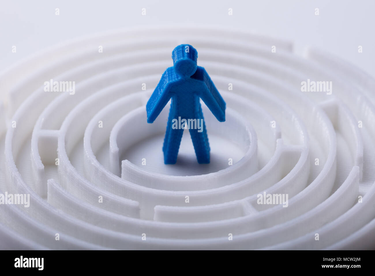 Close-up di blu di una figura umana in piedi nel centro del labirinto Foto Stock
