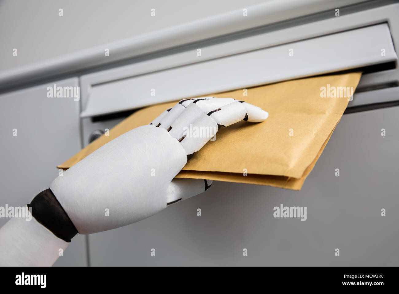 Close-up di una mano robotica di inserimento busta In mailbox Foto Stock Close-up di una mano robotica di inserimento busta In mailbox Foto Stock