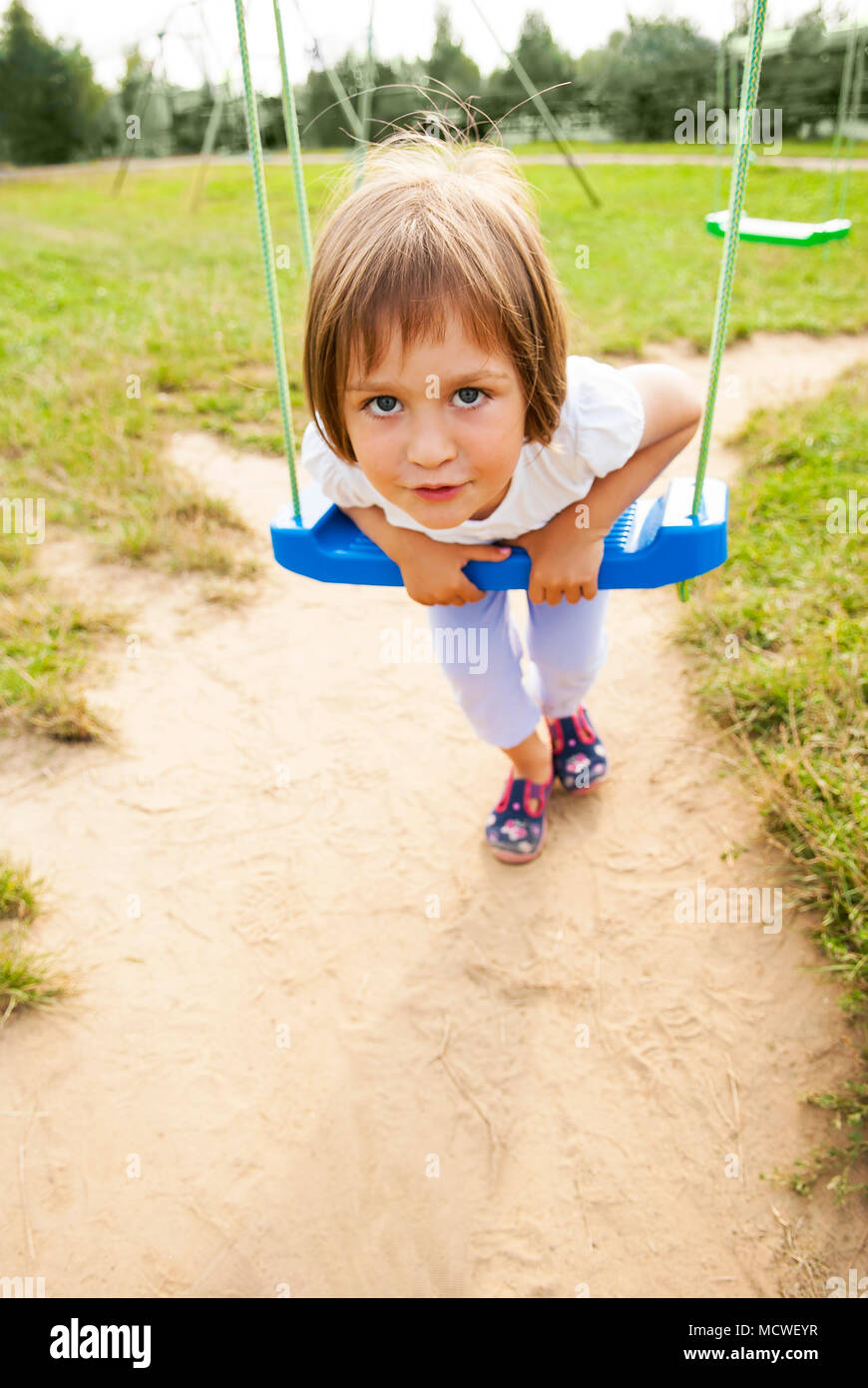 Bambine (tre anni) su un altalena nel parco. Foto Stock