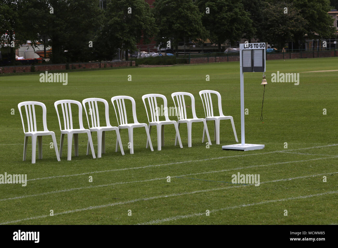 Pista in campo con sedie in plastica bianca da linea di finitura Inghilterra Foto Stock