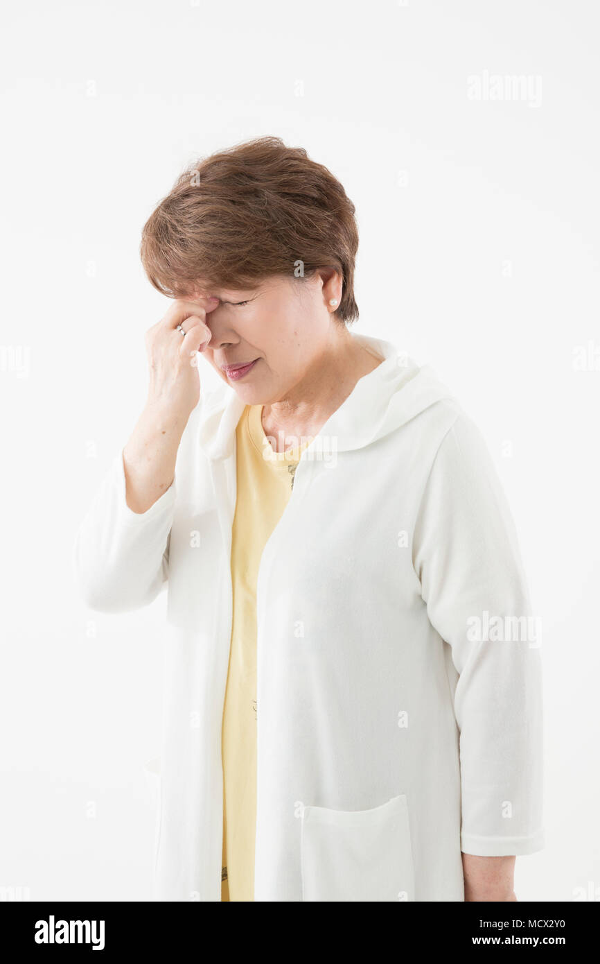 Senior donna con sensazione di affaticamento degli occhi Foto Stock