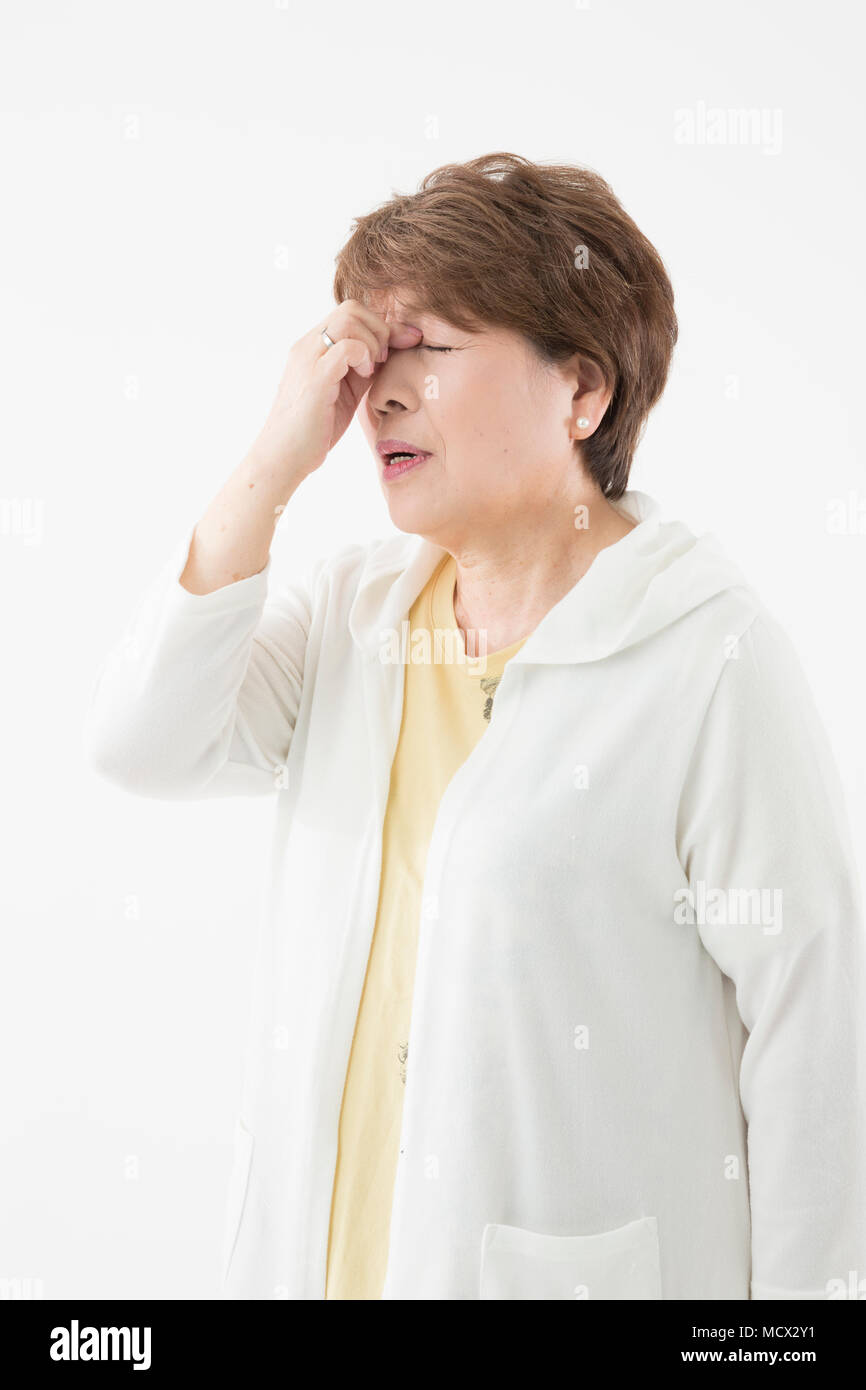 Senior donna con sensazione di affaticamento degli occhi Foto Stock