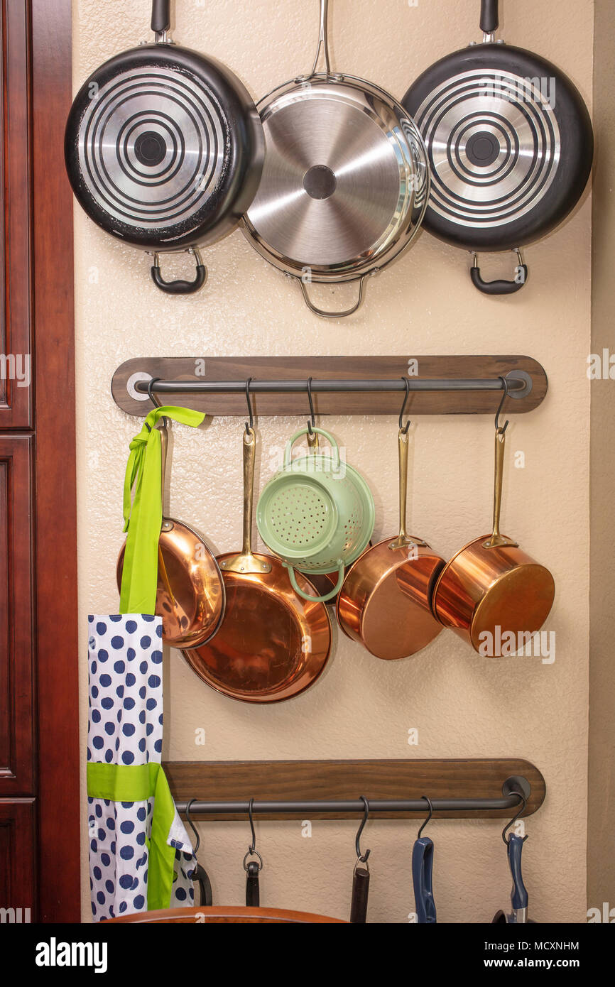 Pentole e padelle appeso a una parete della cucina per risparmiare spazio  Foto stock - Alamy