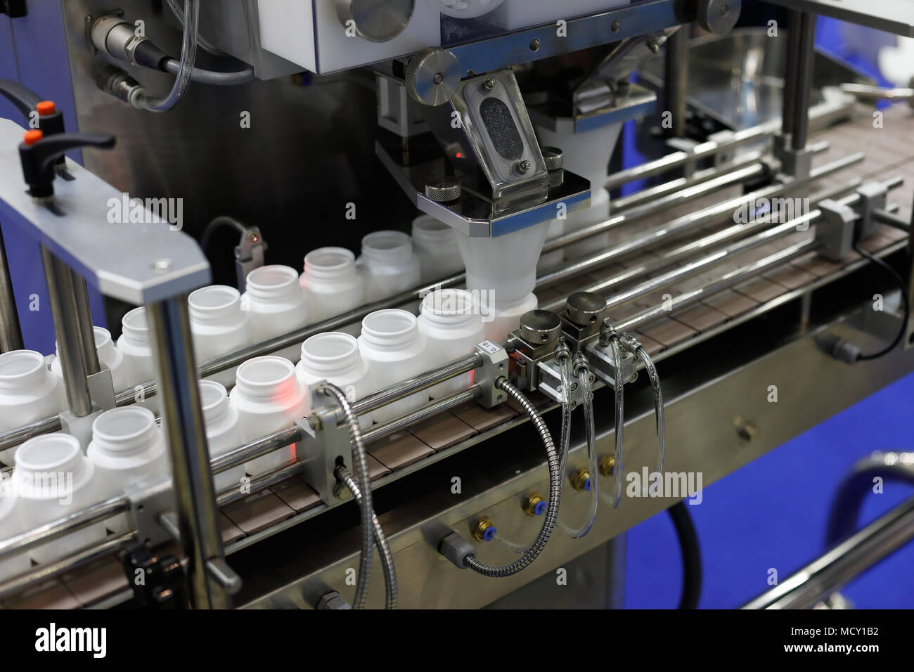 Packaging farmaceutico linea. Di riempimento delle bottiglie con macchina vuota pillola di plastica bottiglie. Foto Stock