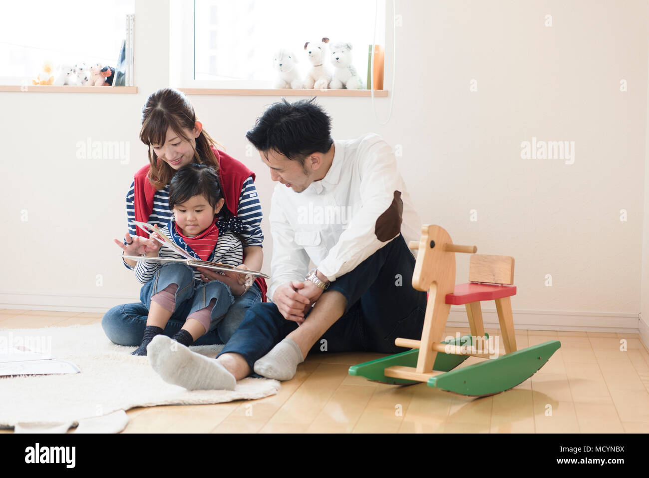 I genitori e il bambino la lettura di un libro Foto Stock