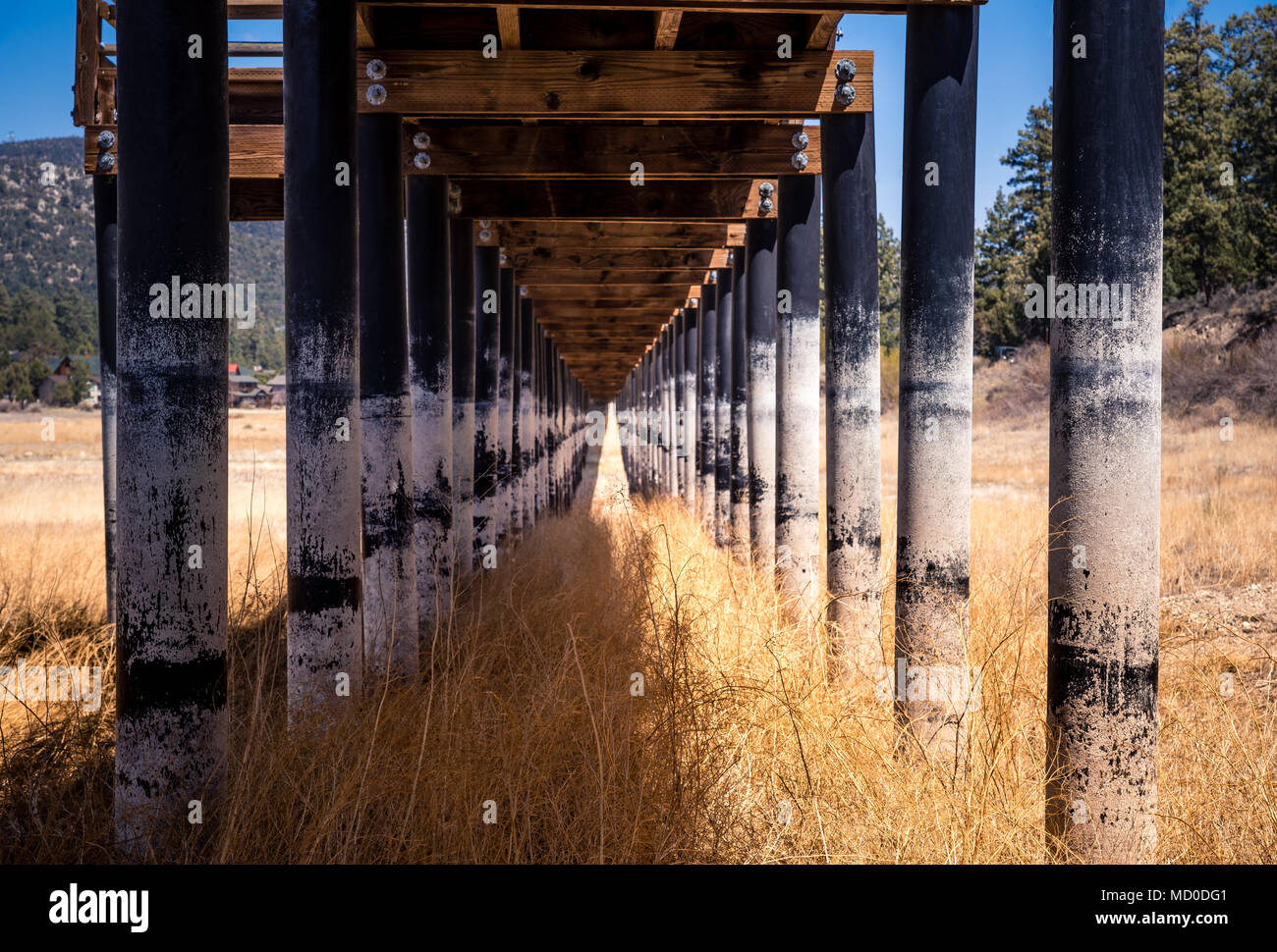 Una passerella di legno su un essiccato fino lakebed. Una vittima della siccità e del tempo. Foto Stock