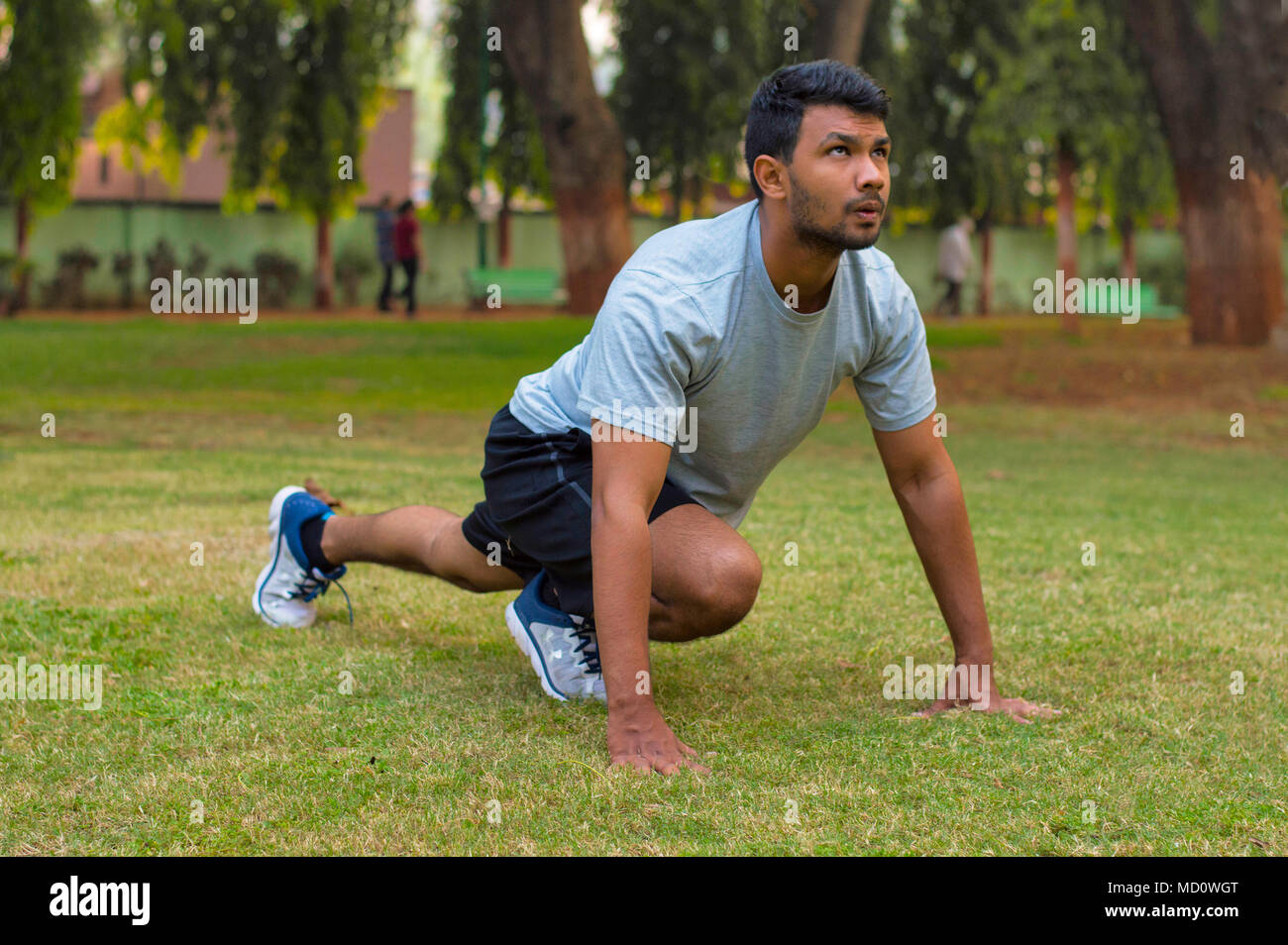 Giovane ragazzo facendo esercizi yoga in un parco Foto Stock