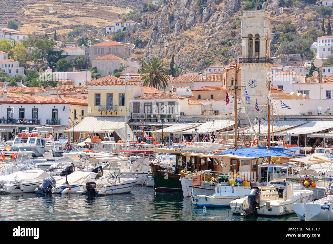 Barche e yacht nel porto di Idra di fronte alla Torre dell Orologio - Isole Saroniche, Grecia Foto Stock