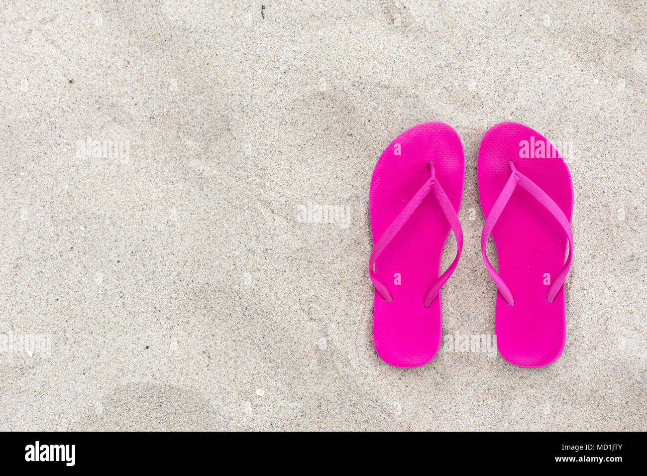 Estate sfondo rosa flip lops sulla sabbia, giorno di spiaggia vacanza vacanze e concetto piatta da laici elevato angolo camera design Per il testo Foto Stock