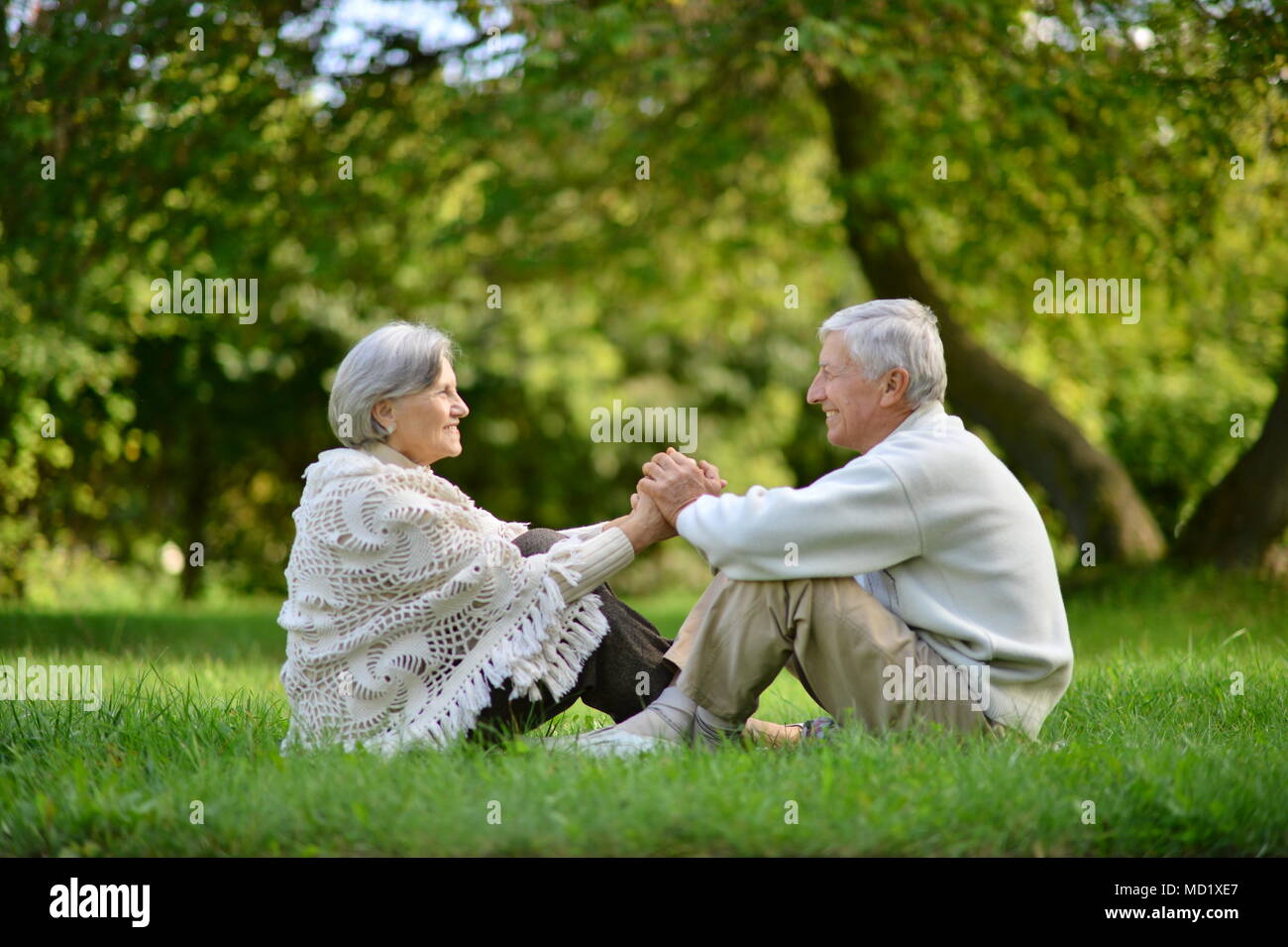 Felice coppia seduta nel Parco di primavera Foto Stock
