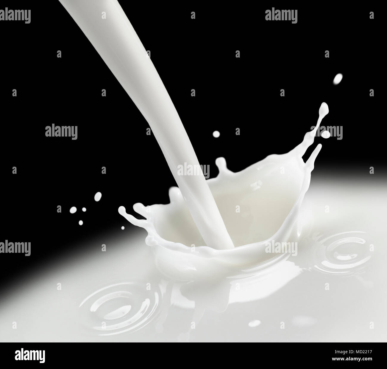 Splash di latte su sfondo nero Foto Stock