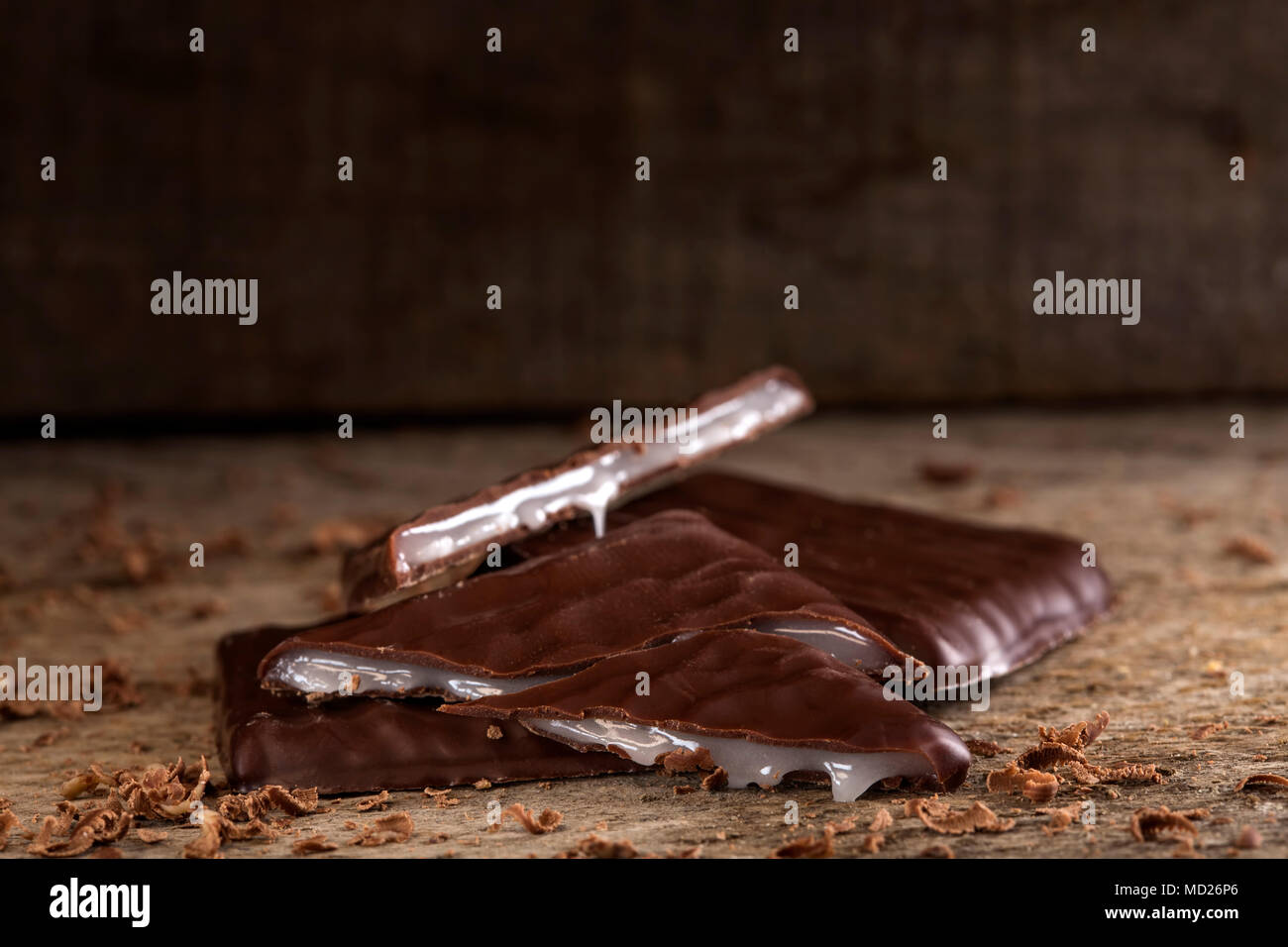 Chiusura del cioccolatino fondente con crema di menta su sfondo di legno Foto Stock