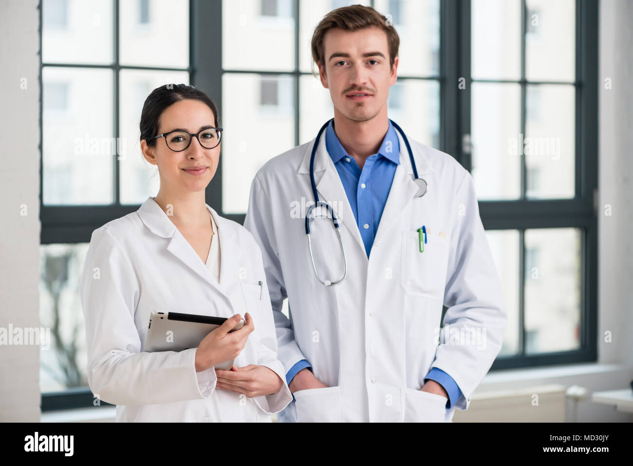 Due medici sorridente in telecamera Foto Stock