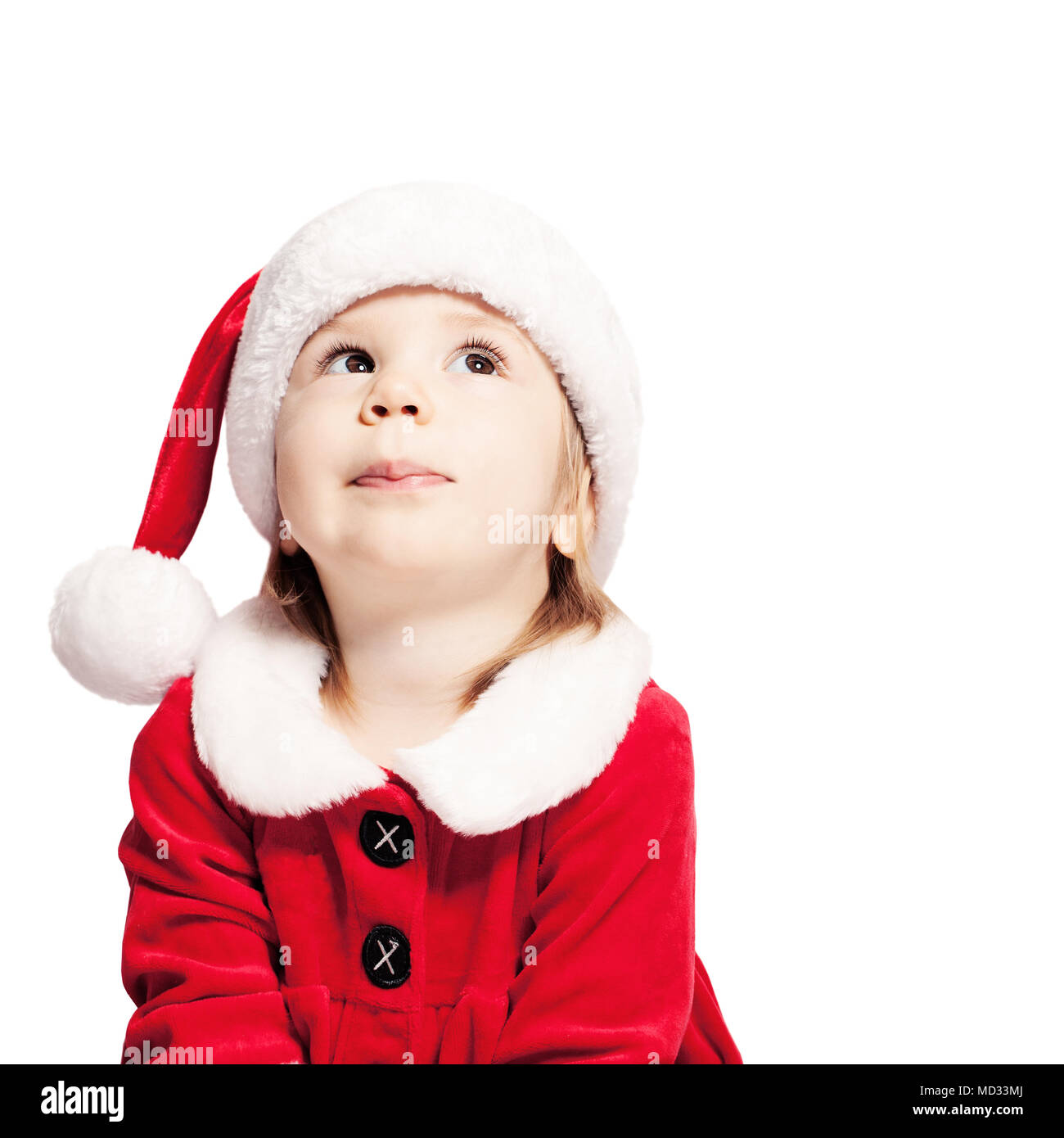 Natale bambino in Santa Hat guardando verso l'alto. Bambino isolato su bianco Foto Stock