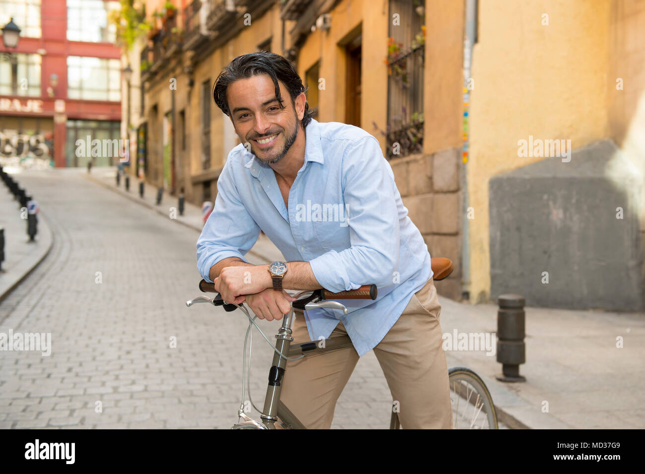 Giovani felici attraente uomo latino in casuale di abbigliamento alla moda  allegra sorridente a cavallo su cool vintage retrò in bicicletta in moderno  stile di vita elegante urban styl Foto stock -