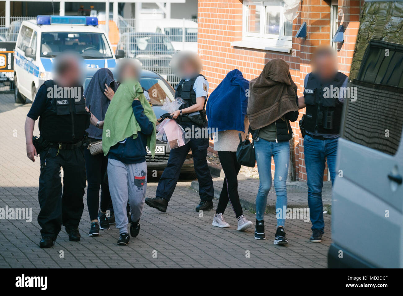 18 aprile 2018, Rastatt, Hannover: le forze di polizia che conduce le donne da una casa nel distretto di Anderten. La polizia si è incrinata giù sulla criminalità organizzata in grande scala, raid su tutto il territorio nazionale a partire da mercoledì mattina. Secondo la polizia tedesca di Stoccarda, la messa a fuoco si trova su forgiato visti, il traffico di esseri umani e sfruttamento e prostituzione forzata di donne Thai. (Le facce sono sfocate per motivi legali) Foto: Ole Spata/dpa Foto Stock