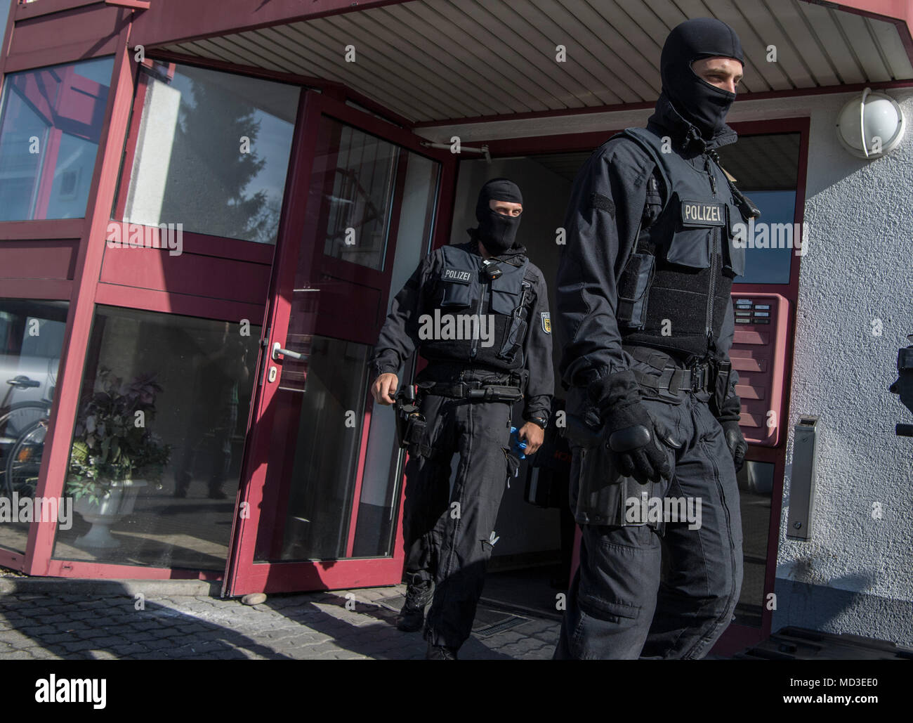 18 aprile 2018, Maintal, Germania: mascherate ufficiali della polizia tedesca durante un raid di un bordello. La polizia si è incrinata giù sulla criminalità organizzata in grande scala, raid su tutto il territorio nazionale a partire da mercoledì mattina. Secondo la polizia tedesca di Stoccarda, la messa a fuoco si trova su forgiato visti, il traffico di esseri umani e sfruttamento e prostituzione forzata di donne Thai. Più di 1500 poliziotti stanno prendendo parte a questo raid. Foto: Boris Roessler/dpa Foto Stock