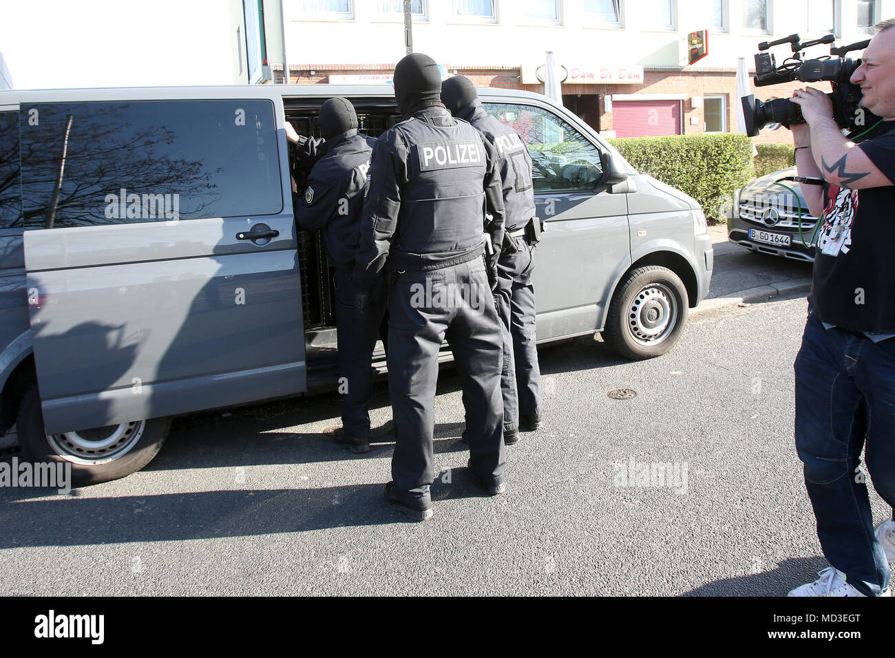 18 aprile 2018, Amburgo, Germania: le forze di polizia tenendo una persona (R) nella custodia. La polizia si è incrinata giù sulla criminalità organizzata in grande scala, raid su tutto il territorio nazionale a partire da mercoledì mattina. Secondo la polizia tedesca di Stoccarda, la messa a fuoco si trova su forgiato visti, il traffico di esseri umani e sfruttamento e prostituzione forzata di donne Thai. Il procedimento giudiziario è nelle mani del pubblico ministero di Francoforte sul Meno. Foto: Bodo segna/dpa Foto Stock