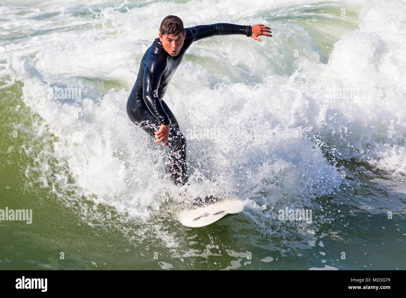 Bournemouth Dorset, Regno Unito. Il 18 aprile 2018. Regno Unito meteo: grandi onde fornire ideali condizioni di surf a Bournemouth Beach il giorno più caldo dell'anno finora. Surfer in azione sulla tavola da surf a cavallo di un onda. Credito: Carolyn Jenkins/Alamy Live News Foto Stock