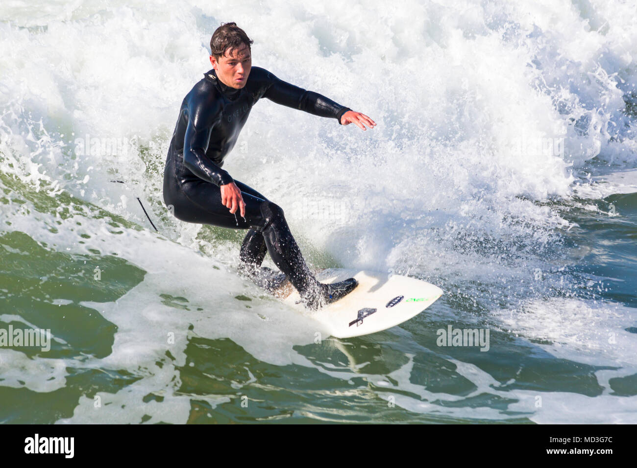 Bournemouth Dorset, Regno Unito. Il 18 aprile 2018. Regno Unito meteo: grandi onde fornire ideali condizioni di surf a Bournemouth Beach il giorno più caldo dell'anno finora. Surfer in azione sulla tavola da surf a cavallo di un onda. Credito: Carolyn Jenkins/Alamy Live News Foto Stock