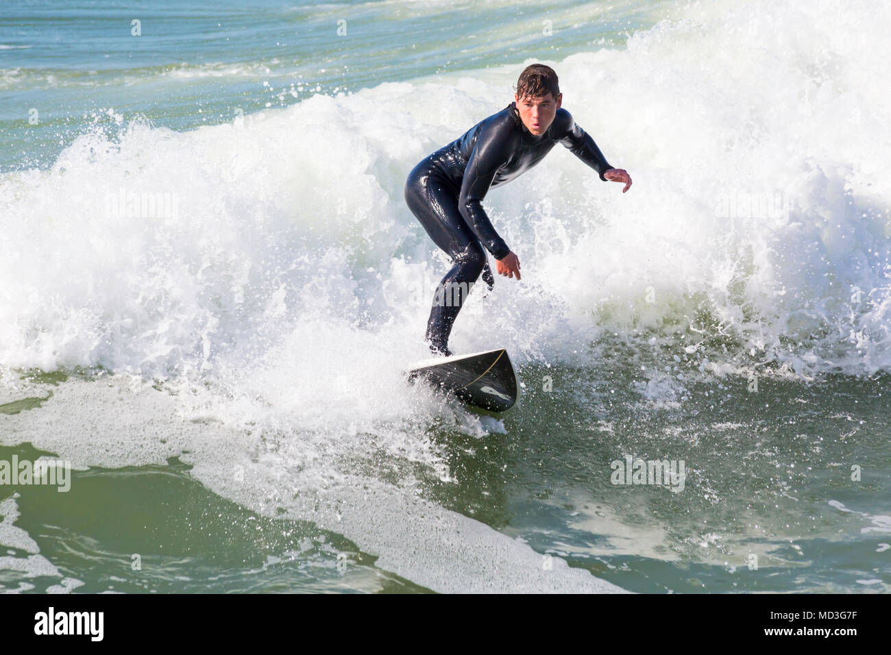 Bournemouth Dorset, Regno Unito. Il 18 aprile 2018. Regno Unito meteo: grandi onde fornire ideali condizioni di surf a Bournemouth Beach il giorno più caldo dell'anno finora. Surfer in azione sulla tavola da surf a cavallo di un onda. Credito: Carolyn Jenkins/Alamy Live News Foto Stock