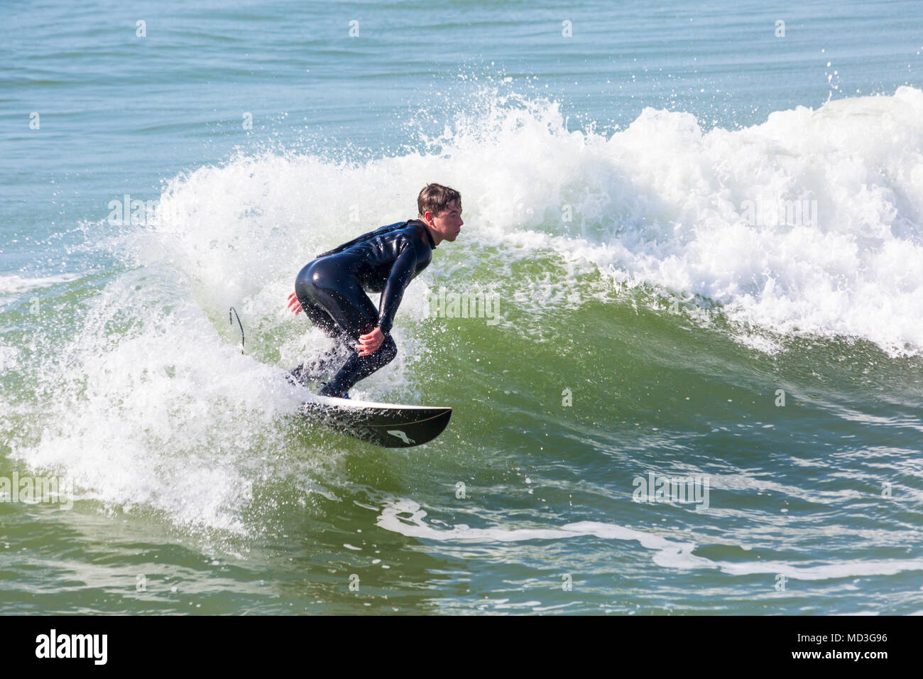 Bournemouth Dorset, Regno Unito. Il 18 aprile 2018. Regno Unito meteo: grandi onde fornire ideali condizioni di surf a Bournemouth Beach il giorno più caldo dell'anno finora. Surfer in azione sulla tavola da surf a cavallo di un onda. Credito: Carolyn Jenkins/Alamy Live News Foto Stock