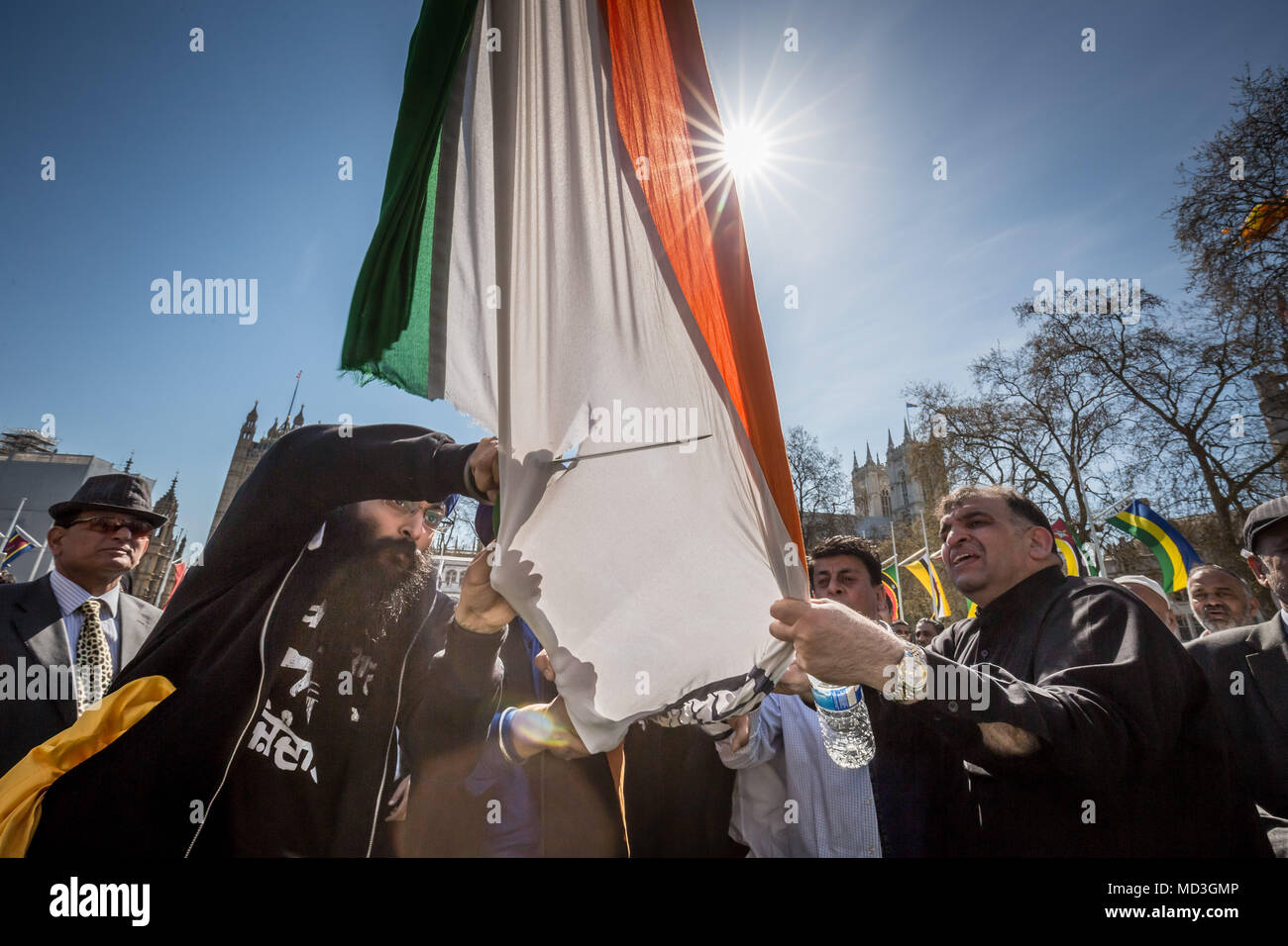 Londra, Regno Unito. 18 Aprile, 2018. La religione Sikh Anti-Modi manifestanti abbattere la bandiera indiana battenti con altre bandiere del commonwealth in piazza del Parlamento durante il organizzato proteste di massa contro Narendra modi, il presidente dell India VISITARE IL REGNO UNITO E INCONTRO CON PM Theresa Maggio a Downing Street. © Guy Corbishley/Alamy Live News Foto Stock