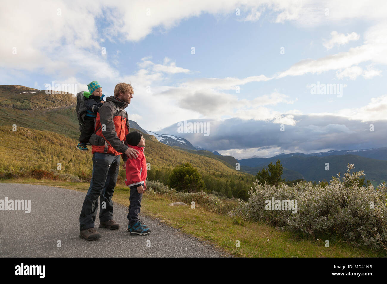 Uomo con figli guardando fuori al paesaggio di montagna, parco nazionale di Jotunheimen, Lom, Oppland, Norvegia Foto Stock