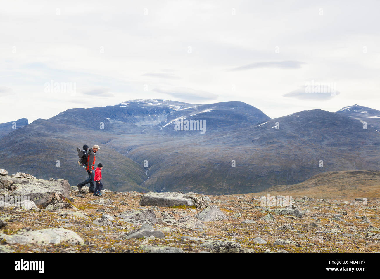 Uomo con figli escursioni nel paesaggio di montagna, parco nazionale di Jotunheimen, Lom, Oppland, Norvegia Foto Stock
