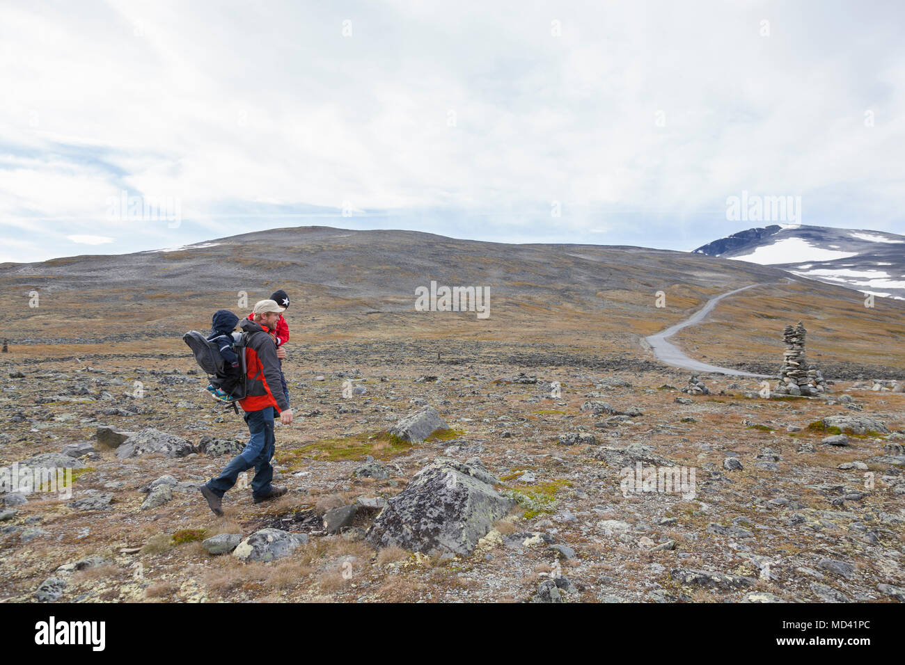 Uomo con figli escursioni nel paesaggio di montagna, parco nazionale di Jotunheimen, Lom, Oppland, Norvegia Foto Stock