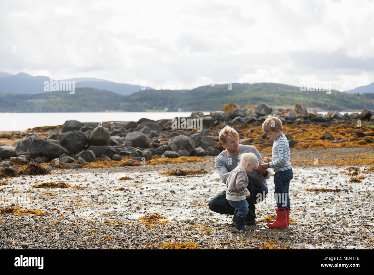 Uomo con figli guardando la natura dal fiordo, Aure, More og Romsdal, Norvegia Foto Stock