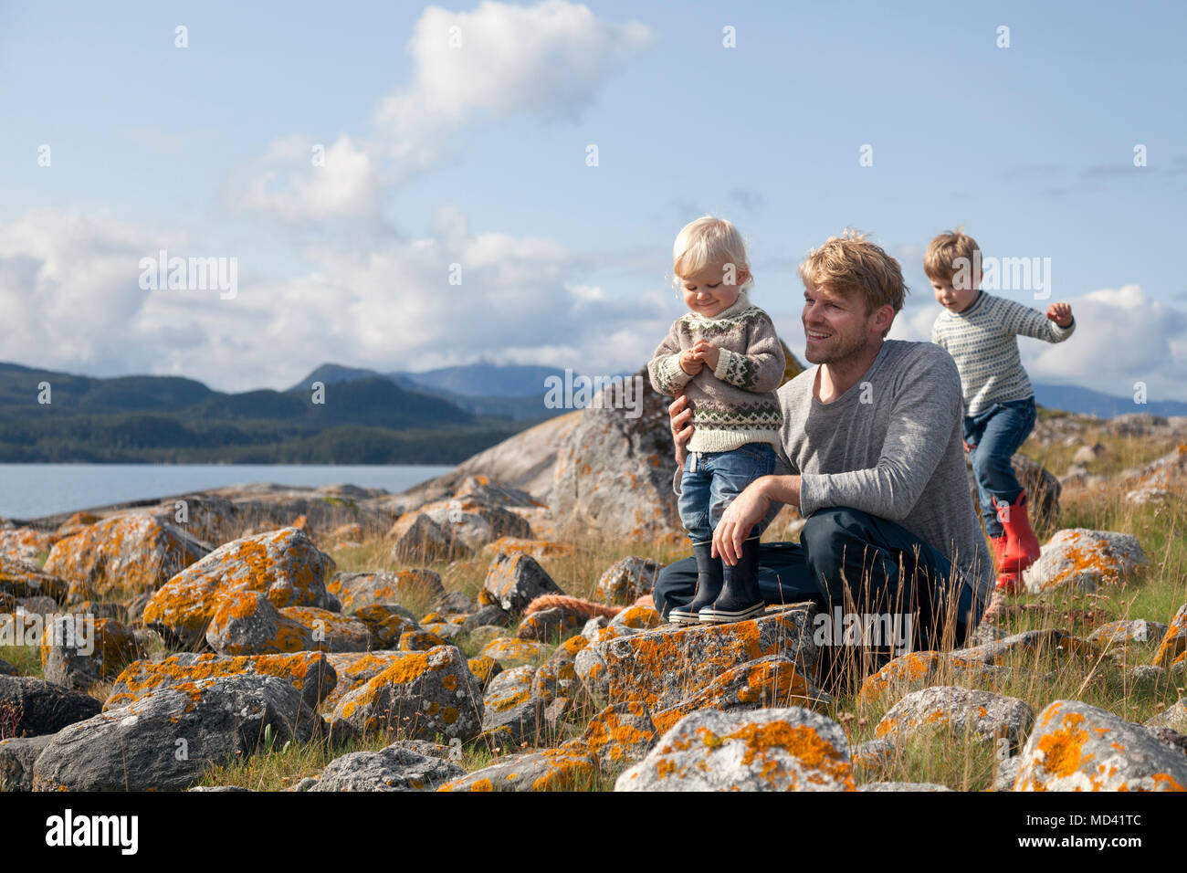 Uomo con figli giocare dal fiordo, Aure, More og Romsdal, Norvegia Foto Stock