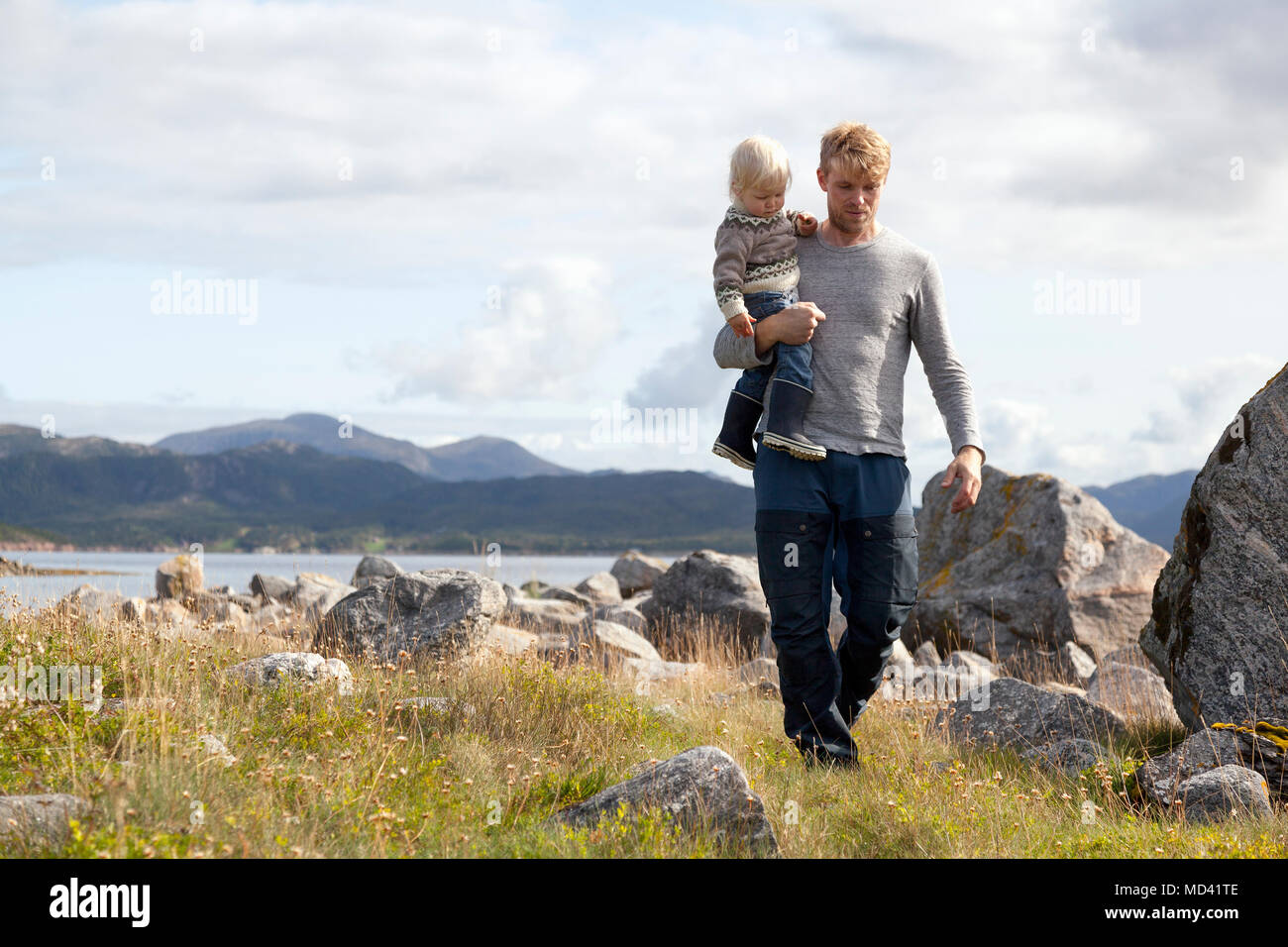 Uomo che porta il figlio dal fiordo, Aure, More og Romsdal, Norvegia Foto Stock