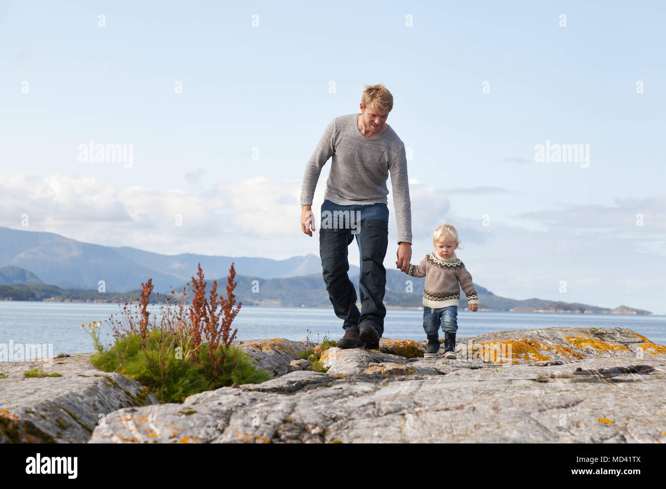 Uomo e figlio passeggiando dalla Fjord, Aure, More og Romsdal, Norvegia Foto Stock