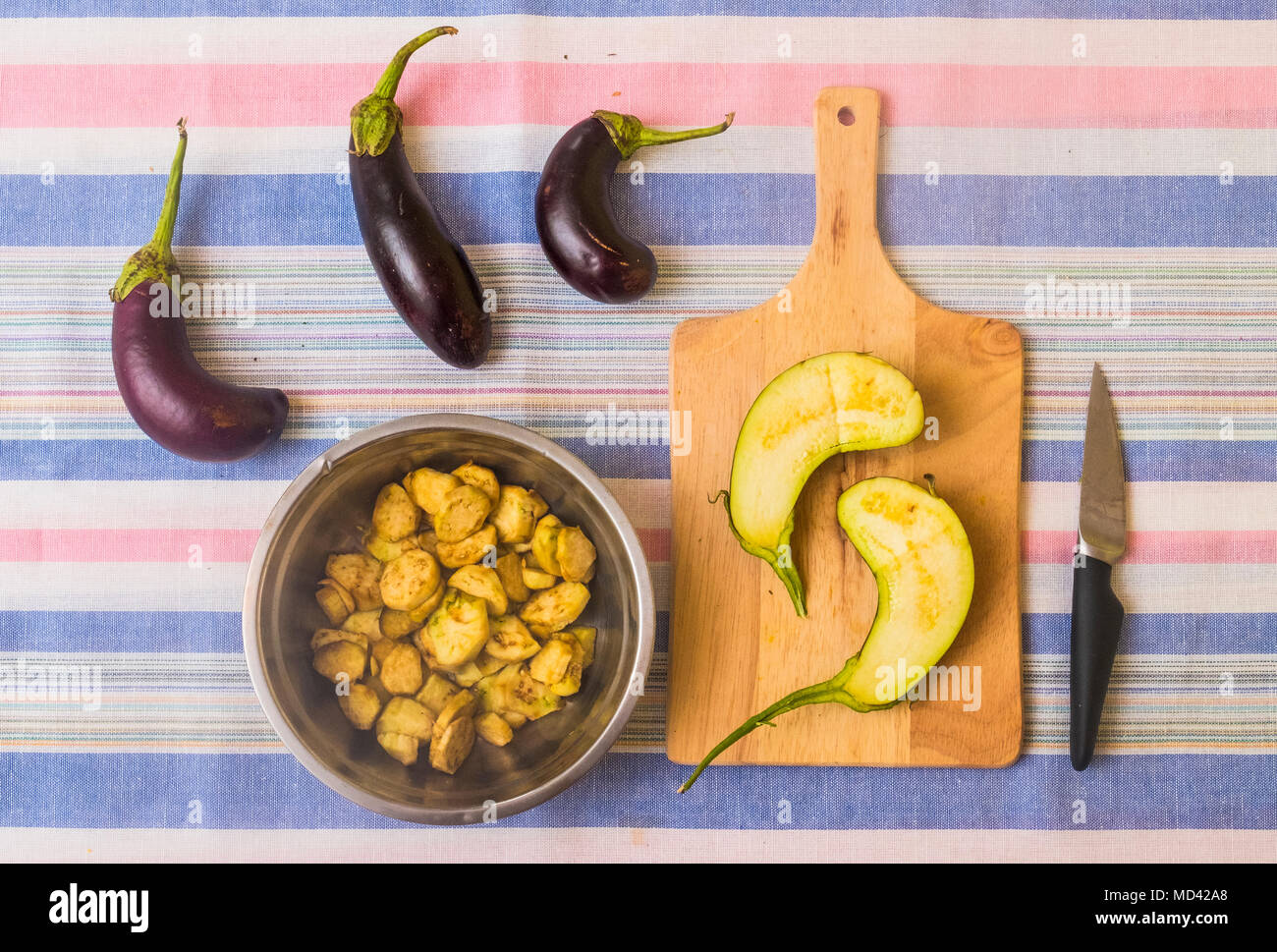 Melanzane, con fette di melanzana sul tagliere e pan con cibo preparato Foto Stock