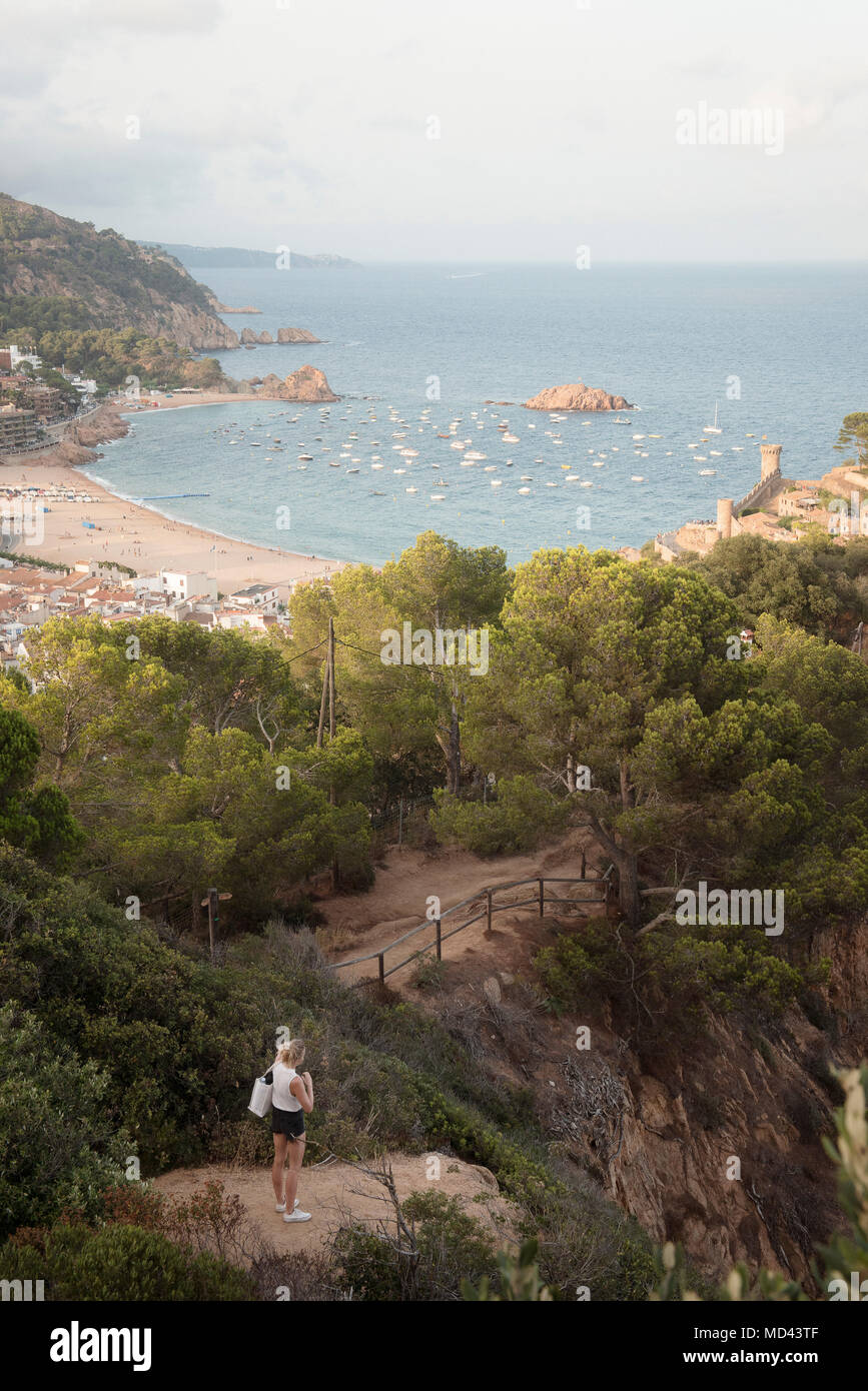 Donna in piedi sulla roccia, guardando a vista, vista in elevazione, Tossa de Mar, Catalogna, Spagna Foto Stock
