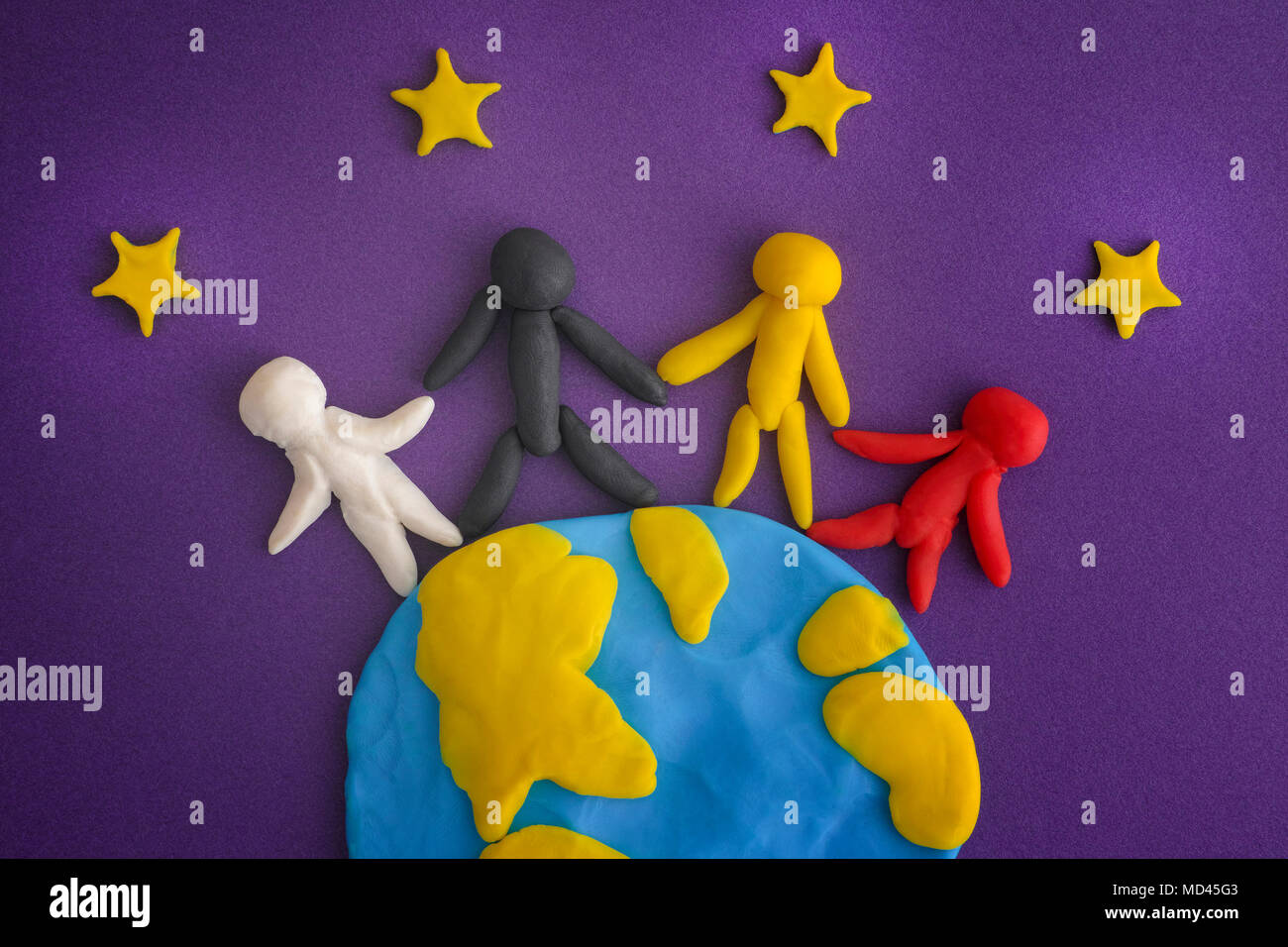 Un gruppo di persone in tutto il mondo. La gente e la terra con le stelle sono realizzati fuori gioco di argilla (plastilina). Close up. Foto Stock