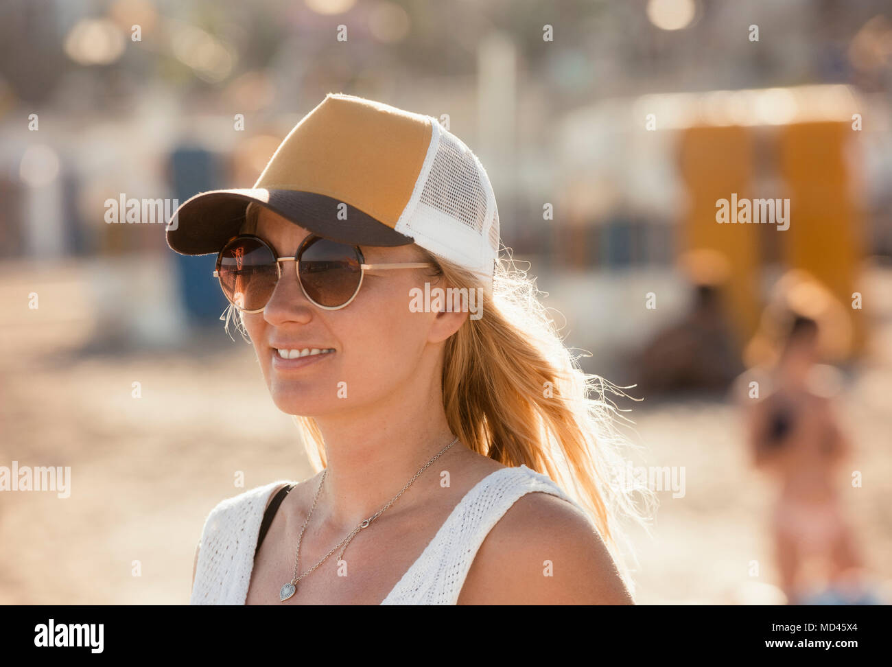 Ritratto di donna sulla spiaggia, indossando occhiali da sole e cappello, Sitges, Catalogna, Spagna Foto Stock