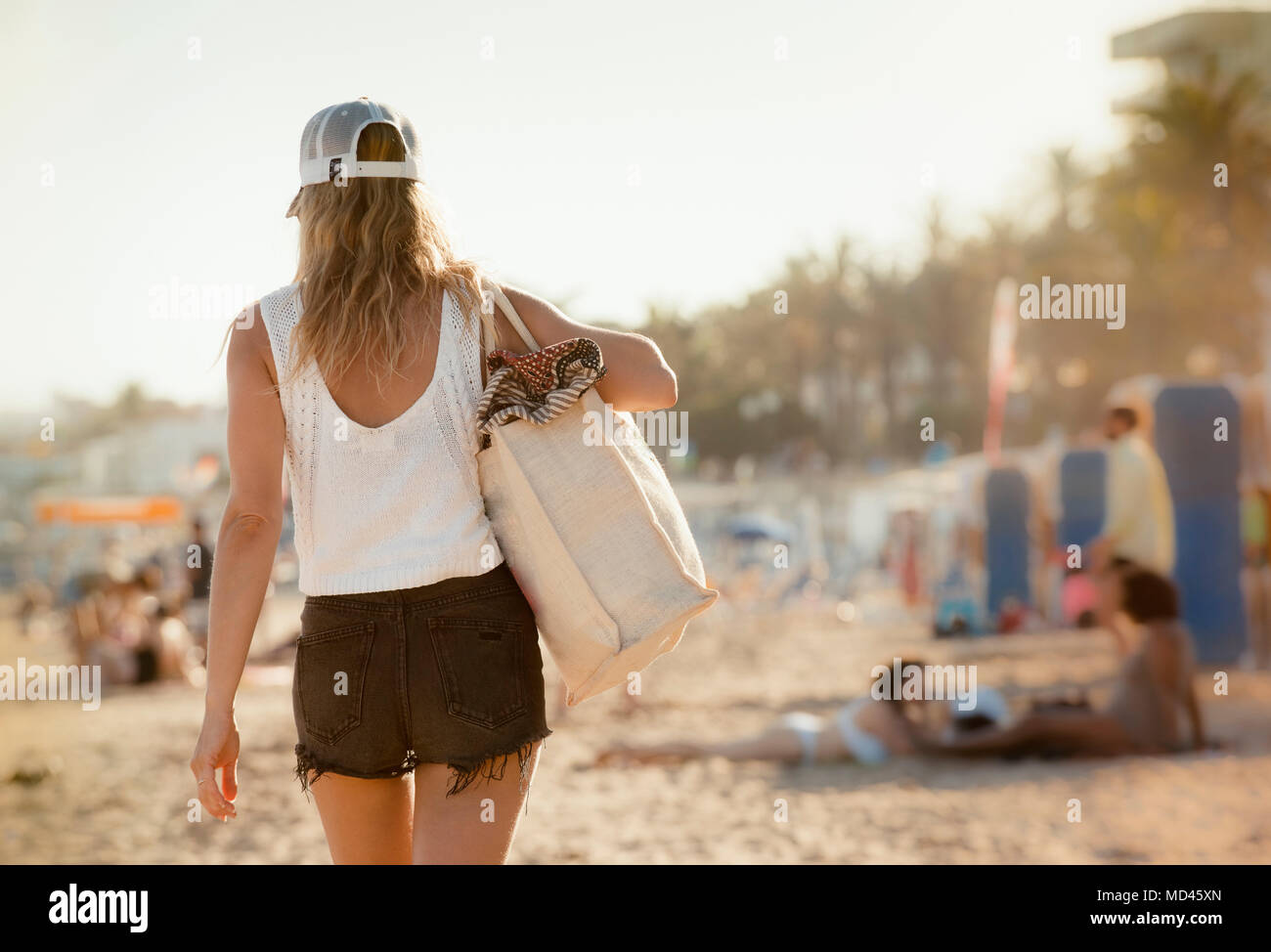 Donna che cammina lungo la spiaggia, vista posteriore, Sitges, Catalogna, Spagna Foto Stock