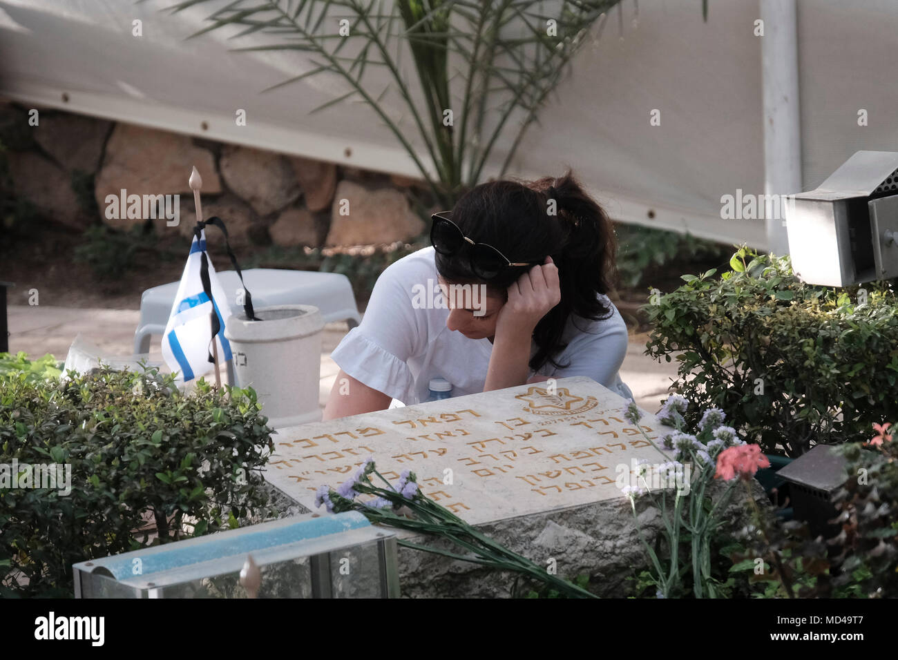 Una giovane donna che piange la tomba di un soldato israeliano caduto nel giorno ufficiale del ricordo di Yom Hazikaron Israel per i soldati caduti delle guerre di Israele e vittime di azioni terroristiche nel cimitero militare nazionale del monte Herzl Gerusalemme ovest Israele Foto Stock