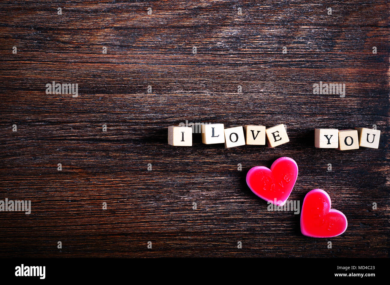 A forma di cuore caramelle da masticare e parole ti amo su cubetti, sullo  sfondo di legno. Spazio libero per il testo Foto stock - Alamy