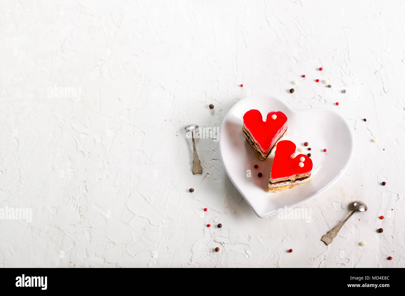 Due jelly heart-shaped torte su cemento bianco sullo sfondo. Spazio libero per il testo Foto Stock