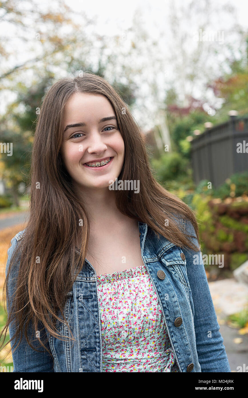 Una ragazza adolescente (13 anni) di sorridere alla telecamera di indossare le bretelle. Foto Stock