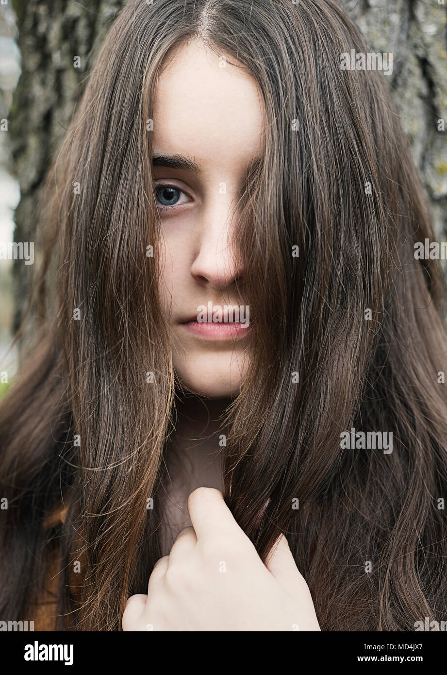 Una ragazza adolescente (13 anni) con i capelli lunghi e guardando la telecamera. Foto Stock