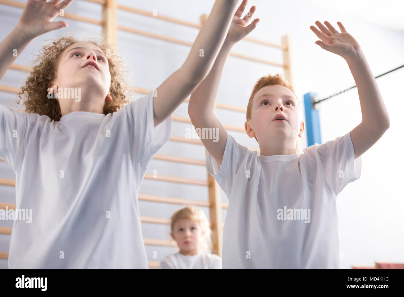 Scolari giocando a pallavolo durante l'educazione fisica classe a scuola Foto Stock