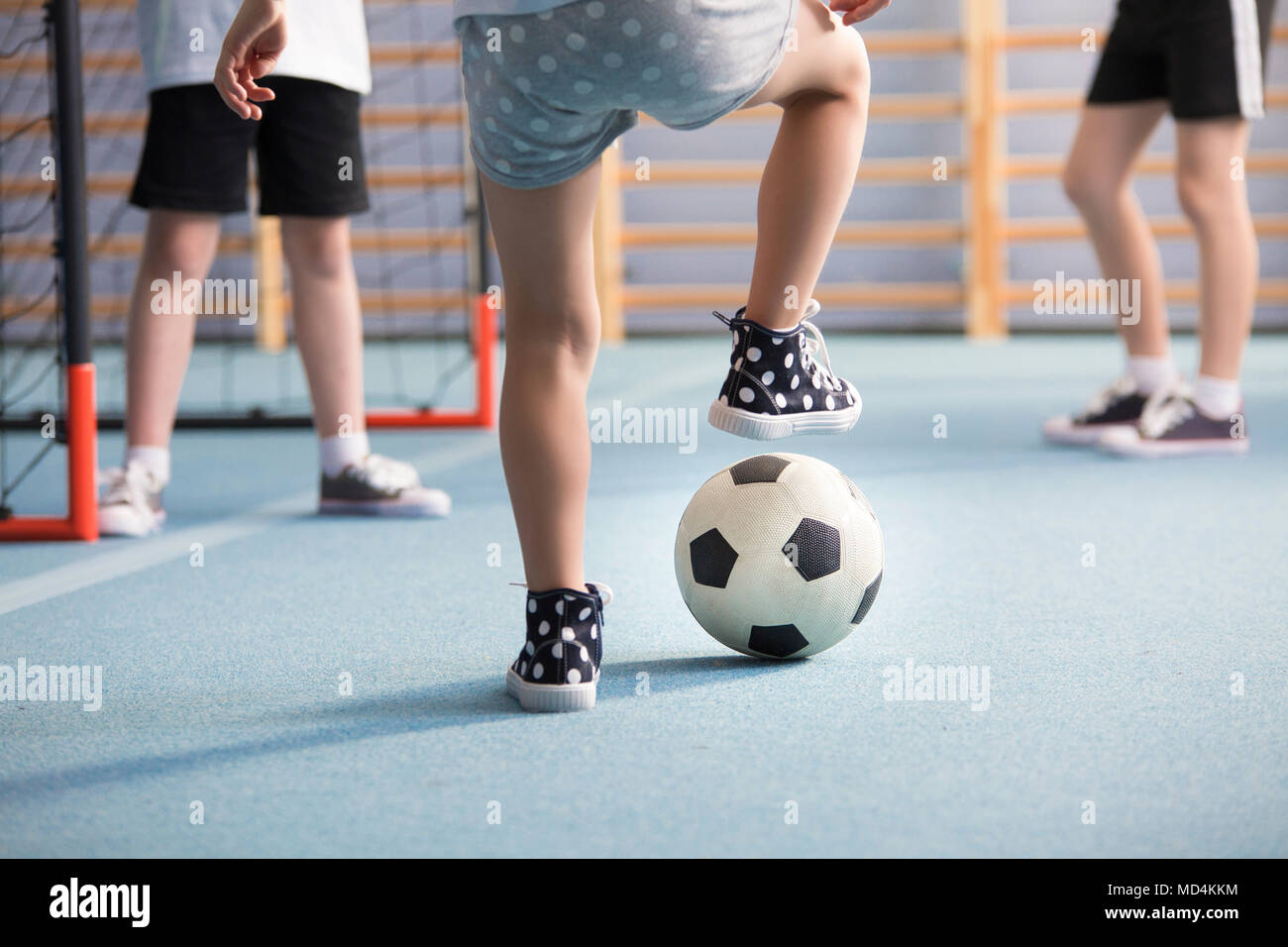 Close-up di ragazzi alle gambe indossando sneakers mentre giocano a calcio nel parco giochi Foto Stock